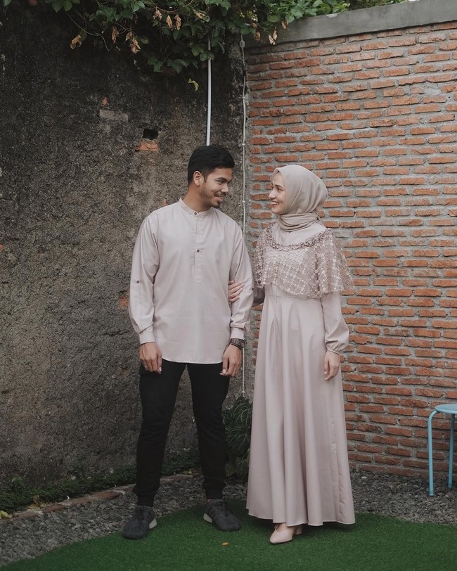 Dwihanda dan suaminya Muhammad Putra tampak matching mengenakan busana bernuansa khaki. Tak harus berdesain sama, Dwhanda tampil feminin dengan aksen lace pada gaunnya, sedangkan sang suami mengenakan baju koko berwarna senada tanpa aksen berlebihan. Foto: Instagram/Dwihanda