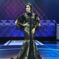 Iis Dahlia bergaya bling bling nan glamour dalam balutan gaun hitam keemasan yang dihiasi bulu di bagian lengannya ini. Foto: Instagram @ isdadahlia