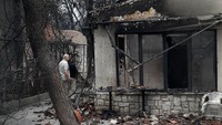 Kebakaran itu menghanguskan ratusan rumah warga setempat. Seorang warga di kota Mati, dekat Athena, sedang memeriksa rumahnya yang hangus akibat kebakaran dahsyat ini. Foto: REUTERS/Costas Baltas