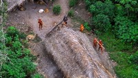 Badannya berwarna kemerahan dan terlihat membidik pesawat dengan panah (Funai/Survival International)