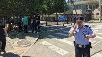 Saat ini, orang-orang berkumpul di luar gedung Kedutaan AS yang diselimuti asap usai ledakan tersebut. Belum ada pernyataan dari pejabat-pejabat China dan Amerika mengenai insiden ini. (Foto: Dok. REUTERS/Thomas Peter)