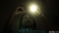 Seorang anak mengabadikan atraksi air mancur menari menggunakan smartphone.