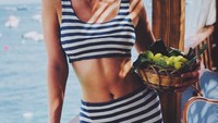 Model 25 tahun ini baru saja dilamar Josh Kushner. Saat di Capri, Italia, Karlie berpose sexy menunjukkan lekuk perutnya. Tak lupa membawa sekeranjang buah segar berwarna hijau. Foto: Instagram karliekloss