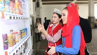 Perwakilan Duta Bank DKI Tahun 2018, Nita Indriani mendampingi sekaligus memberikan edukasi layanan transaksi non tunai melalui aplikasi JakOne Mobile kepada para finalis Abang None DKI Jakarta Tahun 2018 di salah satu Vending Machine Bank DKI di Balaikota, Jakarta. Foto: dok. Bank DKI