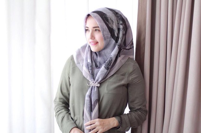 Istri Pasha Ungu, Adelia juga sering tampil mengenakan bentuk hijab ini. Bedanya ia dan selebgram lainnya mengikat hijab segi empat lebih mendekati leher sehingga tali yang menjuntai lebih panjang. Foto: Instagram Adelia Pasha