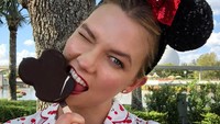 Main ke Disney Land, Karlie merayakan ulang tahun adiknya. Tak lupa pakai bando Mickey Mouse yang lucu sambil menggigit es krim bentuk Mickey Mouse pula. Foto: Instagram karliekloss