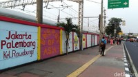 Terlihat mural tersebut sudah dibuat hingga palang perlintasan kereta api di dekat Halte TransJakarta Enjo.