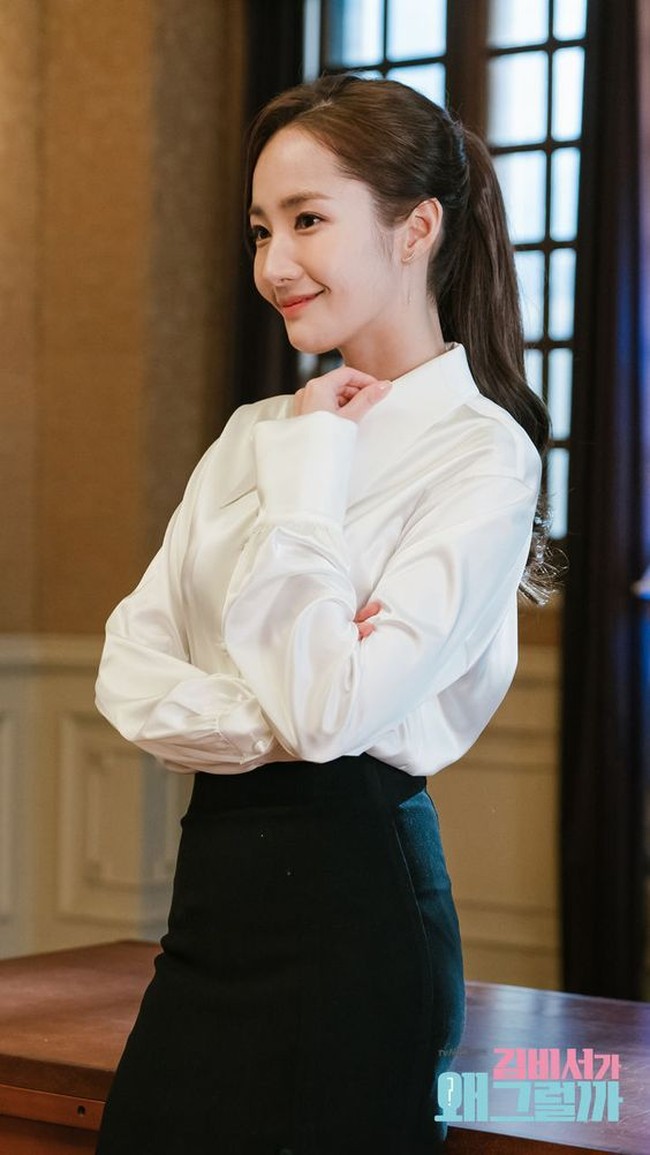 Untuk tampilan yang elegan, Anda bisa memilih kemeja atau blus dengan bahan mengkilap yang lebih tebal. Padukan dengan rok hitam untuk tampilan klasik. Foto: TvN