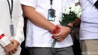 Membawa serta bunga mawar putih masyarakat dan pegawai KPK menggunakan gelang tangan bertuliskan lawan untuk mengungkap kasus penyerangan yang telah melukai Novel Baswedan.