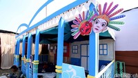 Beberapa pekerja tengah sibuk membangun stand yang didekorasi dengan unsur budaya Betawi yang khas.