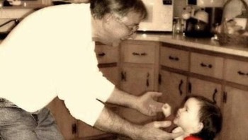 Foto dulu ketika ayah menyuapi makanan ke anak kecilnya. (Foto: Brightside)