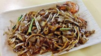 Pendatang baru Bib Gourmand yang tak kalah menarik adalah Lao Fu Zi Fried Kway Teow. Lokasinya ada di Old Airport Road Food Centre dengan menu andalan kway teow harum berwarna kehitaman. Isiannya ada tauge, fish cake dan sosis China atau lap ceung. Foto: Spring Tomorrow