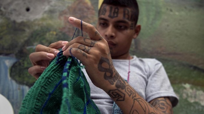 A former member of Barrio 18 gang, crochets a hat during a workshop at the prison of San Francisco Gotera, 161 km east of San Salvador on July 16, 2018.
Members of two of the worlds most feared gangs, El Salvadors Mara Salvatrucha and Barrio 18, prepare to reintegrate into society as they receive a range of classes in jail including DIY, music and knitting as part of a program known as I Change. / AFP PHOTO / Oscar Rivera