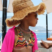 Liburan modis ala Blue Ivy berlanjut dengan bikini bergaya etnik yang dipadu dengan kalung penuh ornamen. Ikut menyempurnakan gaya Blue, kacamata hitam aviator dan topi anyaman. (Foto: Dok. Beyonce Knowles)