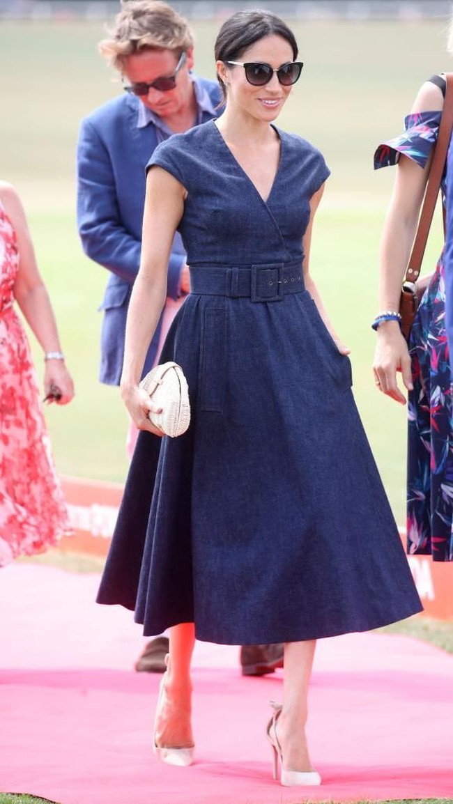 Meghan Markle hari itu tampil klasik tapi ada sentuhan modern dengan dress dari Carolina Herrera. Dress berpotongan A-Line tersebut berbahan denim.  Foto: dok. Getty Images