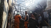 Warga bergotong-royong membantu petugas damkar untuk memadamkan api.