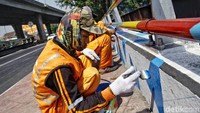 Para petugas PPSU menghias Jembatan Buntung dengan warna-warna cerah.