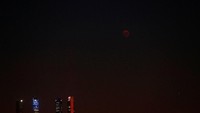 Sebuah bulan purnama naik di atas area gedung pencakar langit selama gerhana bulan terlama abad ke-21 di Madrid, Spanyol, 27 Juli 2018. REUTERS / Paul Hanna