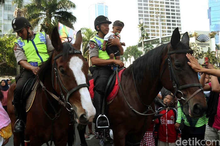 Polisi dari Direktorat Polisi Satwa Mabes Polri yang menunggangi kuda untuk mengawasi keamanan FCD, memperbolehkan anak-anak menaiki kuda tersebut.