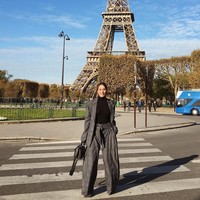 Tampil dengan busana DKNY dan tas Loewe, ibu dua anak itu berpose di depan Menara Eiffel.  Foto: dok. Instagram (@tcjamidah)