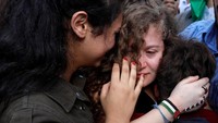 Tamimi terlihat memeluk dua orang kerabatnya. Matanya terlihat sembab.  (Foto: dok Reuters)