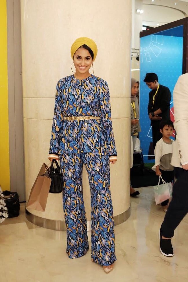 Sisi Bolatini, blogger asal Belanda ini dikenal dengan gaya turbannya yang variatif. Ia hadir di JMFW 2018 hari kedua dengan busana bernuansa biru dan turban kuning yang nyentrik. Foto: Silmia Putri/Wolipop