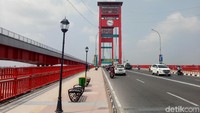 Tak ayal, beberapa pejalan kaki mulai mengabadikan foto di atas jembatan yang membelah sungai Musi tersebut.