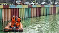 Para petugas menyisir di pinggir hingga tengah Danau Sunter untuk membersihkan waduk tersebut dari sampah.