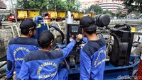 Sejumlah Petugas Sumber Daya Air Aliran Timur dan Barat sedang mengoperasikan mesin pompa penyedot air di kawasan Kali Item.