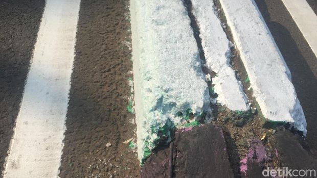 Bercak cat warna-warni masih terlihat di pembatas jalan kawasan Pasar Rebo 
