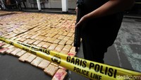 Polisi bersenjata laras panjang menjaga tumpukan ganja yang berhasil disita.