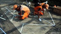 Petugas PPSU membuat pola yang akan dicat di Jalan Medan Merdeka Selatan, Senin (30/7/2018).