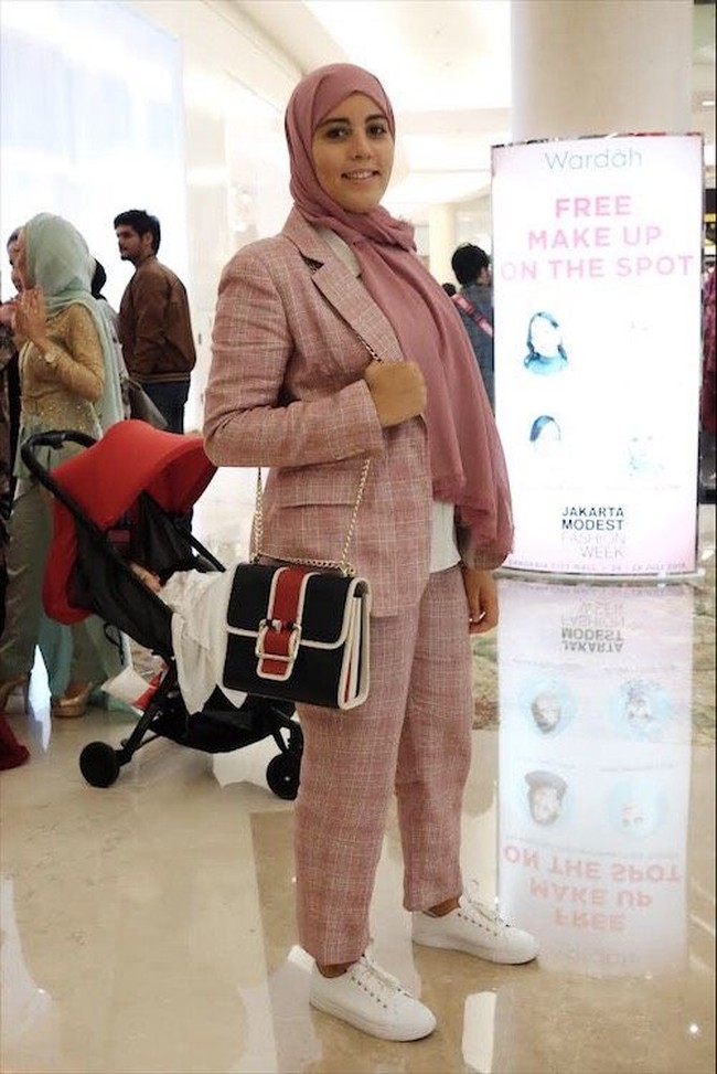 Hanan Challouki tampil memakai blazer set bernuansa merah muda. Founder media muslim Mvslim ini berasal dari Belgia. Ia hadir langsung ke acara JMFW 2018 untuk melakukan liputan khusus sekaligus menjadi pembicara talkshow. Foto: Silmia Putri/Wolipop