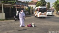 Yang menarik perhatian adalah Mianah salat di tengah jalan sembari menggendong seekor ayam/Foto: Adhar Muttaqin