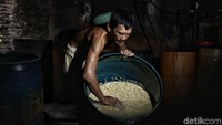 Perajin membuat tempe dengan mengolah kacang kedelai di pabrik rumahan, kawasan Sunter Jaya, Jakarta Utara, Selasa (31/7). 