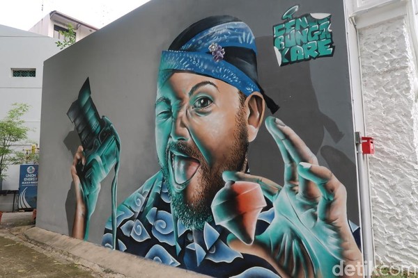 Selain itu, ada pula mural hasil kolaborasi seniman Indonesia dan Singapore. Mural ini berada di samping vintage camera museum. Gambarnya adalah seorang pria yang menggunakan blangkon dan baju batik. Di sampingnya terdapat nama seniman, Cena, Bunga and Kare. (Bonauli/detikTravel) Selain itu, ada pula mural hasil kolaborasi seniman Indonesia dan Singapore. Mural ini berada di samping vintage camera museum. Gambarnya adalah seorang pria yang menggunakan blangkon dan baju batik. Di sampingnya terdapat nama seniman, Cena, Bunga and Kare. (Bonauli/detikTravel)