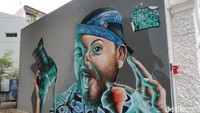 Selain itu, ada pula mural hasil kolaborasi seniman Indonesia dan Singapore. Mural ini berada di samping vintage camera museum. Gambarnya adalah seorang pria yang menggunakan blangkon dan baju batik. Di sampingnya terdapat nama seniman, Cena, Bunga and Kare. (Bonauli/detikTravel)
