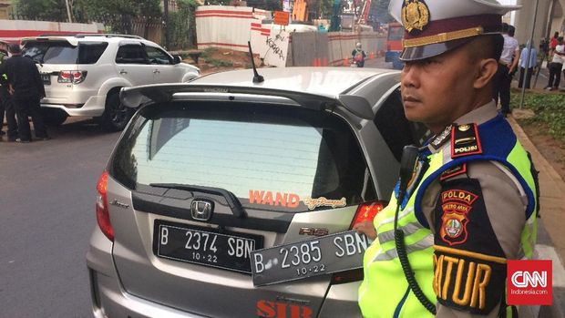 Polisi menilang pengendara mobil yang menggunakan plat nomor palsu untuk mengakali sistem ganjil genap, di Pancoran, Jakarta Selatan, 1 Agustus.