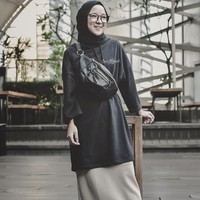 Namun, Nisa Sabyan tetap tampil sopan dengan busana yang oversized dan pencil skirt andalannya. Ia pun senang mencoba tren fashion terbaru ala hypebeast seperti fanny pack dan dad sneakers. Foto: Instagram Nissa Sabyan