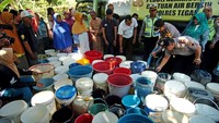 Petugas kepolisian mengadakan kegiatan droping air bersih sebanyak 64.000 liter untuk kebutuhan minum, mandi, dan mencuci warga di Desa Demangharjo, Kabupaten Tegal, Jawa Tengah setelah sebelumnya mengalami kekeringan selama beberapa hari. Antara Foto/Oky Lukmansyah.