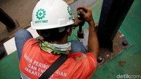 Sejumlah petugas mengalami kendala untuk mencopot  tiang yang menempel di tanah.