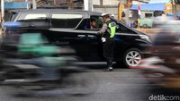Polisi menanyakan kelengkapan surat kendaraan bagi pengendara yang melanggar kawasan ganjil-genap.