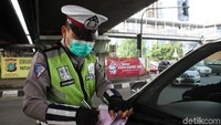 Polisi menilang pengendara yang melanggar aturan ganji-genap.