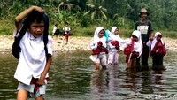 Momen saat anak-anak sekolah dasar Madrasah Ibtidaiyah (MI) dari Kampung Pasirkopo RT 04/06, Desa Wangunreja, Kecamatan Nyalindung, Sukabumi, Jawa Barat, saat menyebrang sungai.
