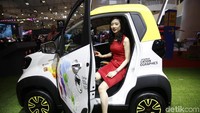 Seorang model berpose di dalam mobil Wuling E100.