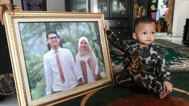 Anak Alex memegang foto ayah dan ibunya