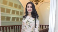 Iis tampil dengan bluss bermotif bungan dan celana putih panjang. Pool/Noel/detikFoto.
