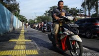 Selain menerobos trotoar, pemotor ini juga tak memakai helm.