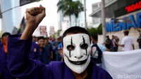 Sambil menggunakan topeng para massa aksi menyuarakan aspirasi mereka.