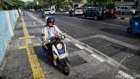 Pengendara sepeda motor dengan santainya melintas di jalur yang bukan peruntukannya.